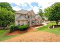 A two-story brick home with a well-manicured lawn and mature trees around the property at 101 Misty Valley Dr, Canton, GA 30114