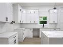 A modern kitchen with white cabinets, quartz countertops, and stainless steel appliances at 262 Crumley St Sw, Atlanta, GA 30312