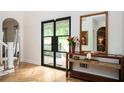 Welcoming foyer featuring hardwood floors, a console table with flowers, and double doors to the porch at 5102 Chastleton Dr, Stone Mountain, GA 30087