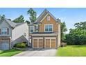 Two-story home featuring a well-manicured lawn and a two-car garage at 5880 Crestwick Way, Cumming, GA 30040