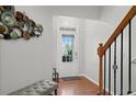 Bright foyer with wood floors, staircase, and decorative wall art at 5880 Crestwick Way, Cumming, GA 30040