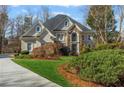 Attractive two-story home featuring a stone facade, arched entryway, well-manicured lawn, and mature landscaping at 2502 Oak Hill Ovlk, Duluth, GA 30097