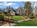 Two story home with mature landscaping, stone facade, well manicured lawn and a wooden walkway at 2502 Oak Hill Ovlk, Duluth, GA 30097