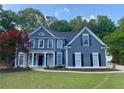 Charming two-story home featuring blue siding, black shutters, manicured lawn, and welcoming front entrance at 219 Maple Creek, Woodstock, GA 30188
