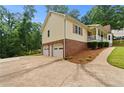 Side view of house showing brick foundation, 2 car garage and landscaped yard at 670 Dena Dr, Canton, GA 30114