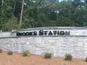 Stone sign at Brooks Station community entrance surrounded by lush greenery at 1288 Hollingsworth Way, Dacula, GA 30019