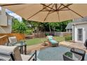 Backyard patio with comfortable seating arrangement and large umbrella perfect for outdoor relaxation at 1294 Parkview Nw Ln, Kennesaw, GA 30152