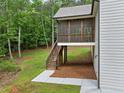 Exterior view of the home's screened porch, stairs and back yard area surrounded by trees at 210 Joe Green Ln, Canton, GA 30114