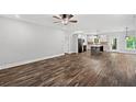 Open-concept living space featuring wood floors, a ceiling fan, and a view of the kitchen at 210 Joe Green Ln, Canton, GA 30114