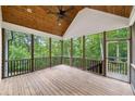 Inviting screened porch with wood flooring, ceiling fan, wood ceiling and view of the surrounding trees at 210 Joe Green Ln, Canton, GA 30114