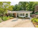 Well-maintained home featuring a circular driveway, manicured landscaping, and a classic white exterior at 6825 Castleton Dr, Atlanta, GA 30328