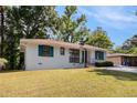 A single-story home with a well-maintained lawn, showcasing its crisp white exterior and turquoise door and shutter trim at 2070 Brannen Se Rd, Atlanta, GA 30316