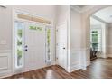 Inviting foyer with hardwood floors, white trim, and a sidelight window at 2430 Tack Hill Ct, Dacula, GA 30019