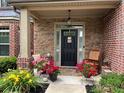 Inviting front porch with stone accents, potted flowers, and a cozy rocking chair at 2430 Tack Hill Ct, Dacula, GA 30019