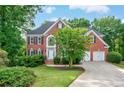 Charming brick home with a two-car garage, well-kept lawn, and mature landscaping at 4910 Aldbury Ln, Suwanee, GA 30024