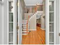 Elegant foyer with hardwood floors, staircase with white risers, and views to kitchen at 4910 Aldbury Ln, Suwanee, GA 30024