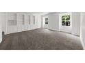 Spacious room featuring gray carpeting, built-in shelving, and natural light from two windows at 789 Houston Mill Ne Rd # 5, Atlanta, GA 30329