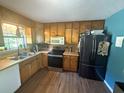 Efficient kitchen with stainless steel appliances and wooden cabinets with laminate floor at 124 Tyler Dr, Mcdonough, GA 30252