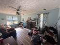 Cozy living room with fireplace, ceiling fan, large window, and natural light at 124 Tyler Dr, Mcdonough, GA 30252