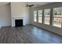 Spacious living room with a fireplace, ceiling fan, hardwood floors, and lots of natural light at 214 Saratoga Dr, Acworth, GA 30102
