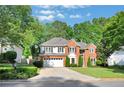 Charming two-story brick home featuring well-maintained landscaping and inviting curb appeal, surrounded by mature trees at 1411 Blackland Trl, Lawrenceville, GA 30043