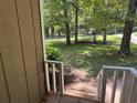 View from the porch onto the home's spacious front yard with mature trees and distant structure at 3594 Broxton Ln, Snellville, GA 30039