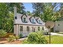 Exterior view of a charming Cape Cod-style home with a covered front porch and mature landscaping at 944 Pine Ridge Dr, Stone Mountain, GA 30087