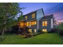 Exterior view of a two-story house with a deck, patio, and a lush green lawn at twilight at 440 Laurian Nw Way, Kennesaw, GA 30144