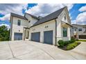 Side angle view of a spacious three-car garage and large driveway of a two-story home at 4992 Concert Ln, Marietta, GA 30066