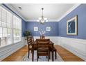 Traditional dining room featuring hardwood floors, wainscoting, and a classic chandelier at 998 Regal Hills Ln, Mableton, GA 30126