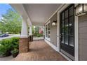 Inviting covered front porch with brick flooring, offers a welcoming entrance with stylish lighting fixtures at 998 Regal Hills Ln, Mableton, GA 30126
