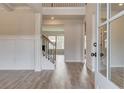 Bright foyer featuring hardwood floors, an elegant staircase, and views into the living spaces at 242 Linford Dr, Locust Grove, GA 30248