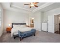 Main bedroom with a tray ceiling, carpeted floors, a bench, and an ensuite bathroom at 3949 Glenview Club Ln, Duluth, GA 30097