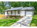 Lovely home featuring a welcoming porch, garage and a beautiful yard with new sod at 4043 Chedworth Way, Stone Mountain, GA 30083