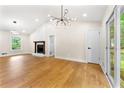 Bright living room featuring hardwood floors, stylish lighting, a stone fireplace, and large windows with a view at 4043 Chedworth Way, Stone Mountain, GA 30083