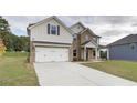 Inviting two-story home showcasing brick and siding, a manicured lawn, and a two-car garage at 238 Linford Dr, Locust Grove, GA 30248