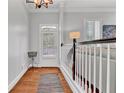 Light-filled hallway showcasing hardwood floors, white wainscoting, and a view to the front door at 4676 Ivygate Se Cir, Atlanta, GA 30339