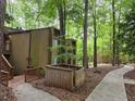 Exterior view of townhomes surrounded by mature trees and landscaping with walking path at 5826 Par Four Ct, Lithonia, GA 30038