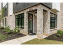 Charming front door with brick surround and black frame, inviting entrance to a modern home at 1954 8Th St, Chamblee, GA 30341