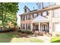 Attractive brick townhouse with black shutters, a covered entry, and manicured lawn at 2610 Oglethorpe Ne Cir, Brookhaven, GA 30319