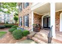 Lovely covered front porch with brick steps, seating area, and well-maintained landscaping at 2610 Oglethorpe Ne Cir, Brookhaven, GA 30319