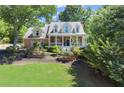 Inviting brick home with a covered front porch, set amidst a lush green lawn and mature trees at 2936 Summitop Ne Rd, Marietta, GA 30066