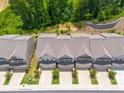 An aerial shot showing the layout of townhomes, each with a two-car garage and manicured front yards, surrounded by green trees at 6780 Cedar Glen Rd, Peachtree Corners, GA 30360