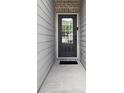 A well-lit front entrance with a gray door featuring a glass pane, offering a welcoming entry to the home at 6780 Cedar Glen Rd, Peachtree Corners, GA 30360