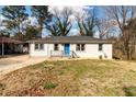 Lovely single-story home boasts a bright blue front door and a well-manicured lawn at 3224 Canary Ct, Decatur, GA 30032