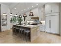 Bright, modern kitchen featuring a large island with seating, white cabinetry, and stainless steel appliances at 320 Shady Grove Ln, Alpharetta, GA 30009