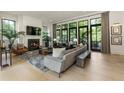 Sunlit living room boasts a fireplace, hardwood floors, and large windows with backyard views at 320 Shady Grove Ln, Alpharetta, GA 30009