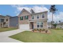 Beautiful two-story home with a brick and siding facade, lush green lawn, and a double garage at 320 Tulip Dr, Covington, GA 30016
