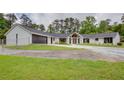Beautifully renovated white brick home with a modern garage door and lush green lawn in a serene, wooded setting at 4700 Cascade Sw Rd, Atlanta, GA 30331