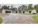 Striking renovated home with a large manicured lawn, contrasting black trim, and an expansive circular driveway at 4700 Cascade Sw Rd, Atlanta, GA 30331